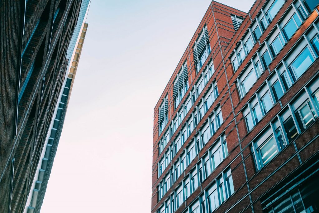 low-angle-shot-of-concrete-apartment-buildings-with-a-lot-of-windows